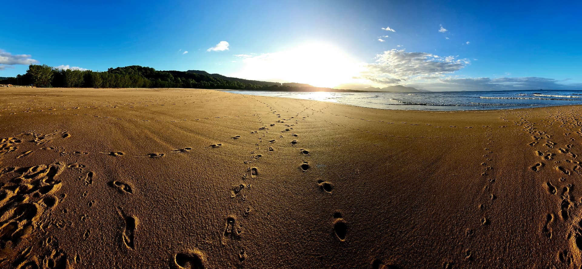 Footprints along the wide open sand of Bramston Beach