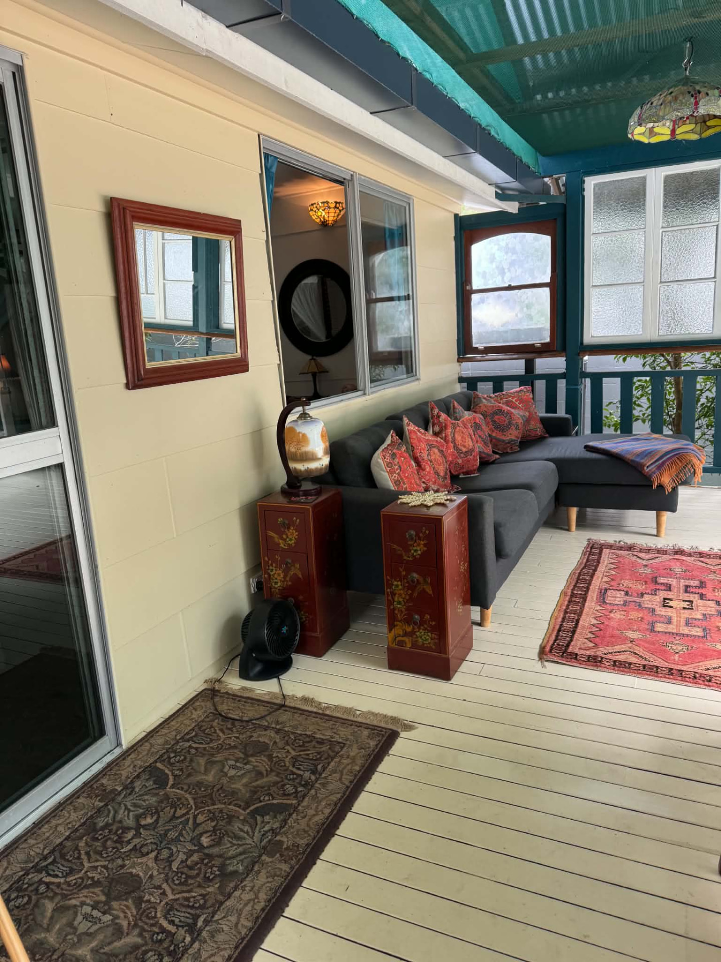 Covered verandah with daybed, Persian rug and Tiffany lamp