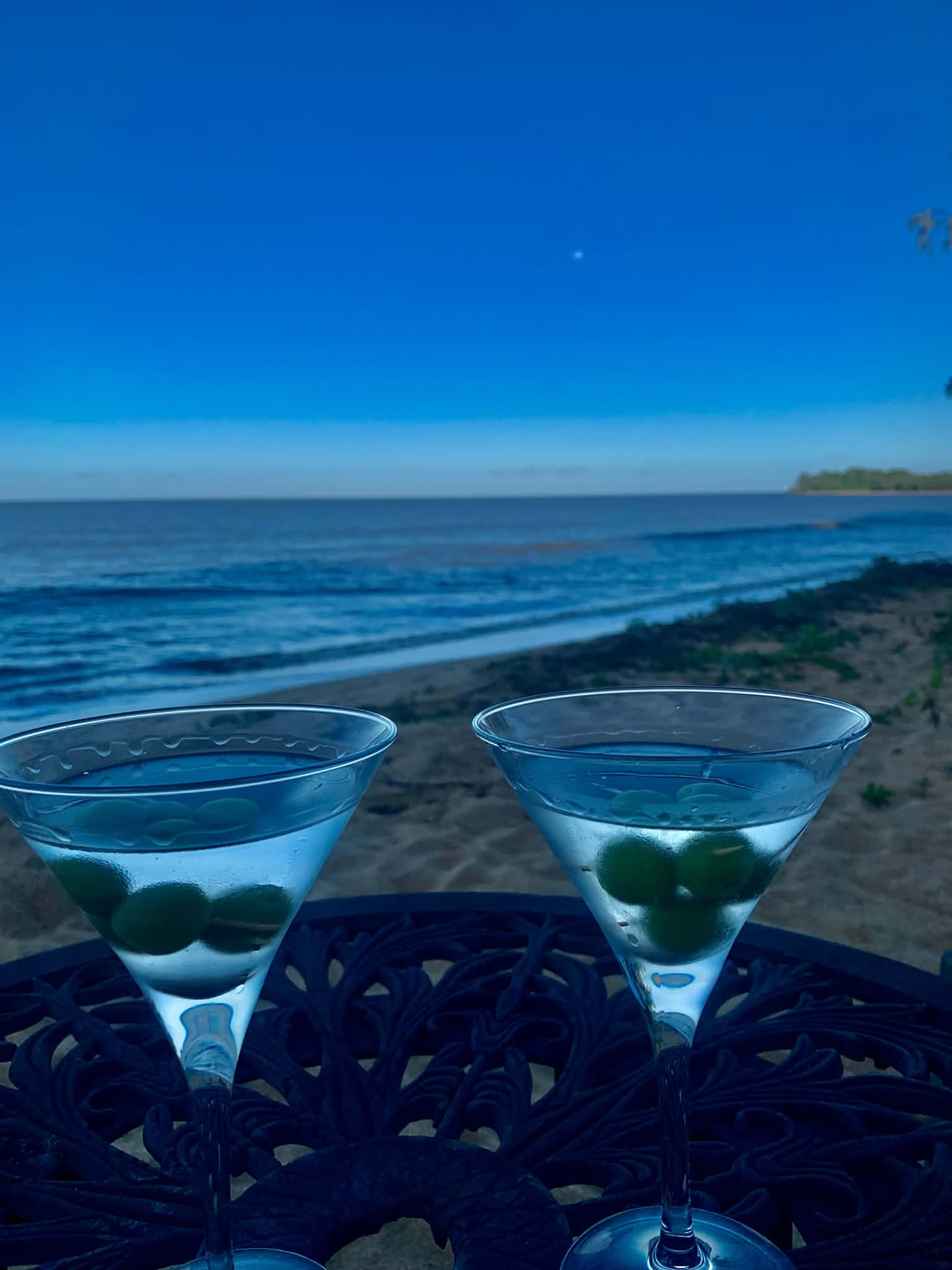 Two martini glasses on a table overlooking the Coral Sea