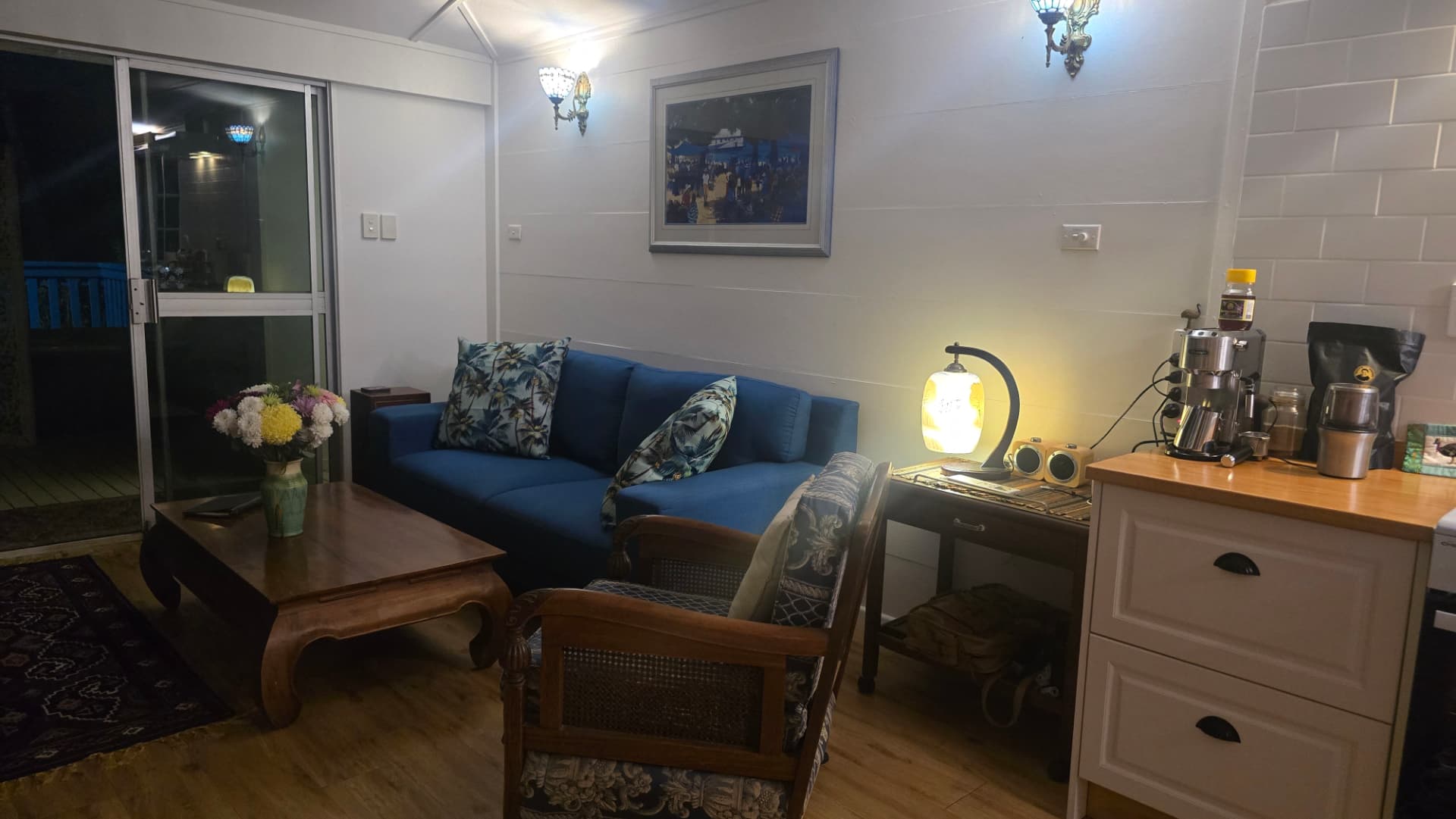 Lounge in warm lamplight with fresh flowers and coffee station