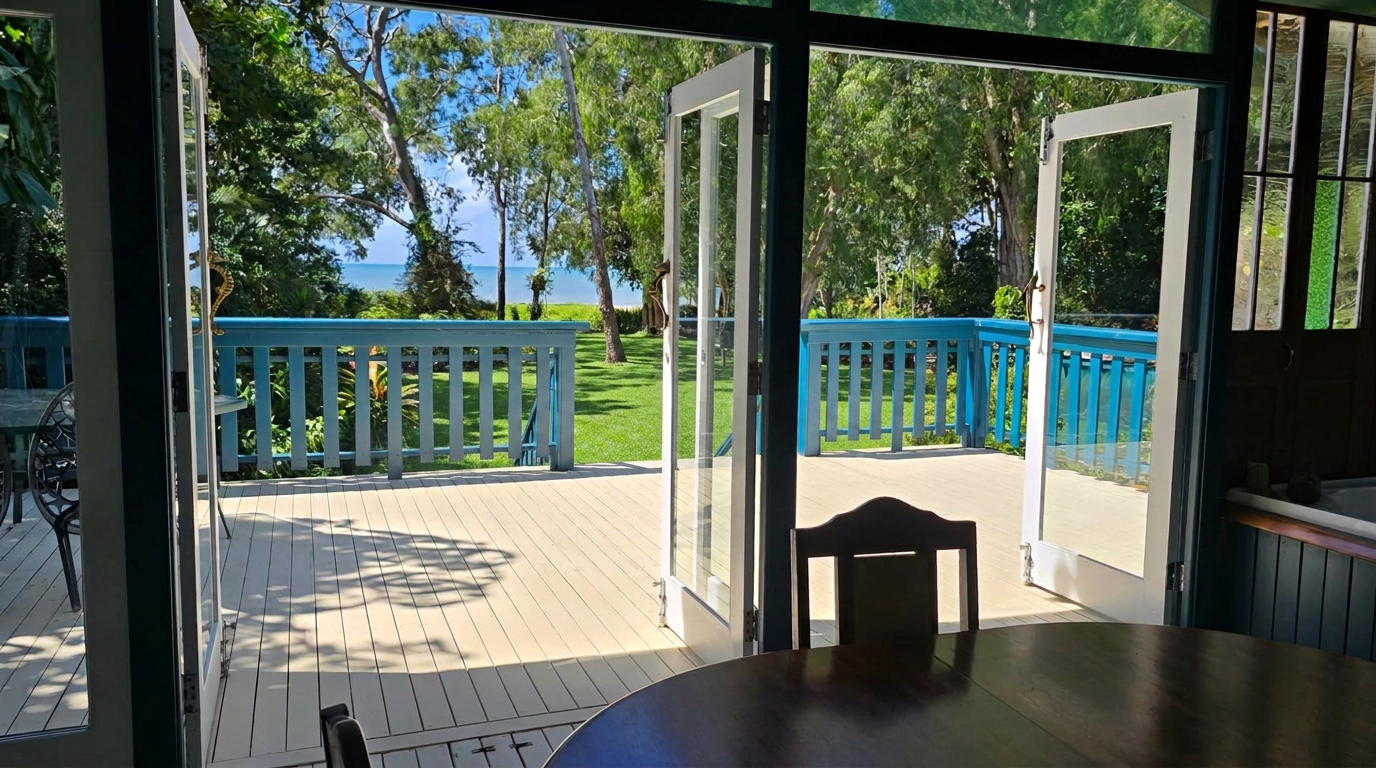 Open French doors leading to the wide deck and ocean view