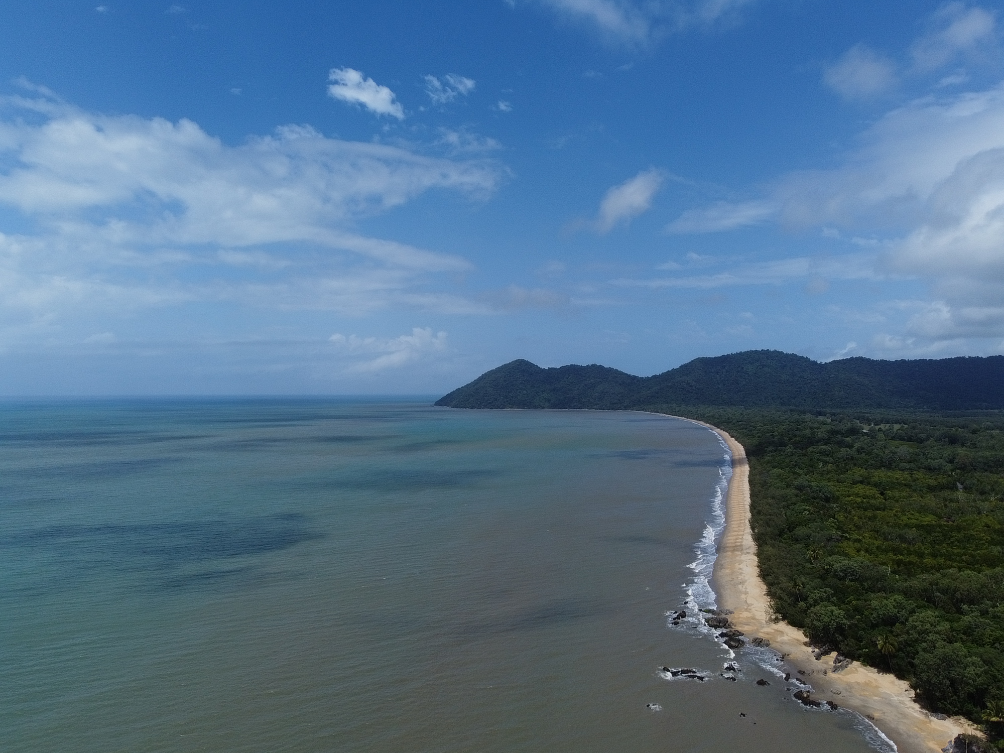 Aerial view of the long sandy beach and calm Coral Sea